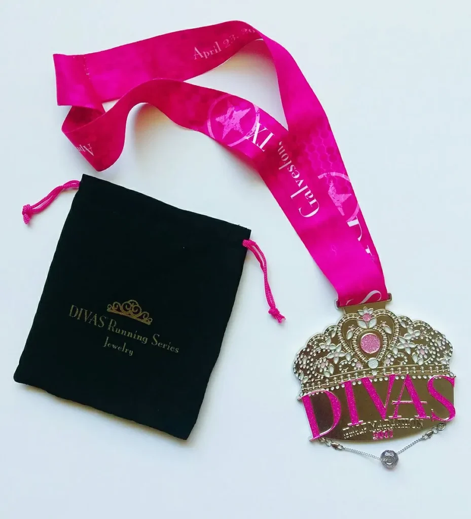 A medal with a pink ribbon next to it.