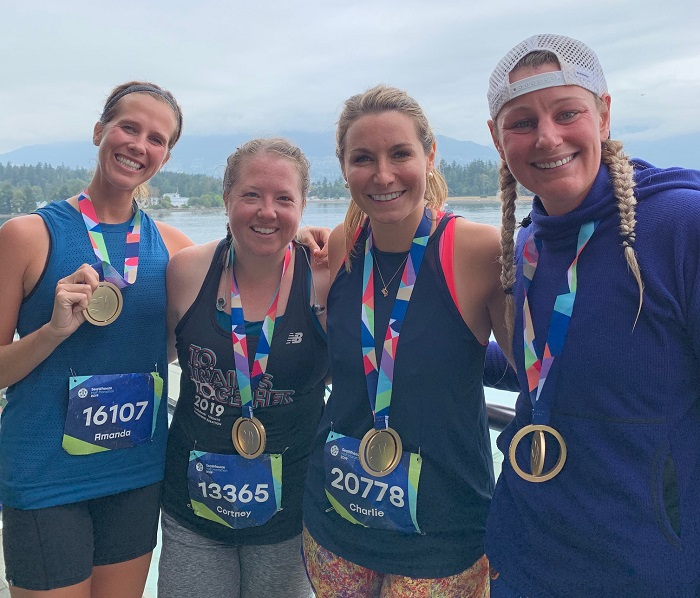 Four women posing for a photo with their Seawheeze medals.